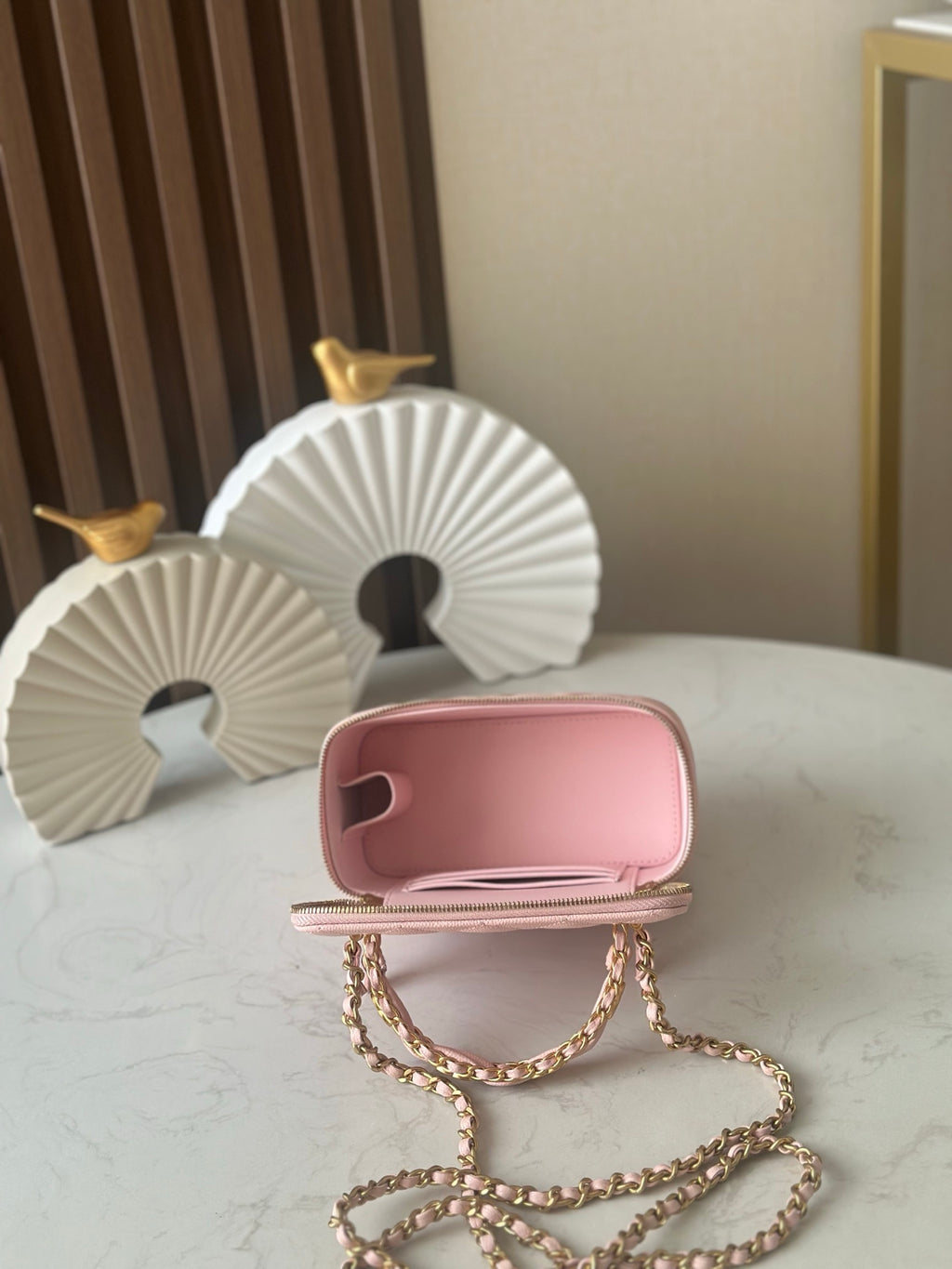 Chanel mini bag back view in light pink with gold chain strap and zip closure