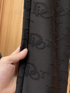 Close-up of black Dior monogram fabric texture on the leg