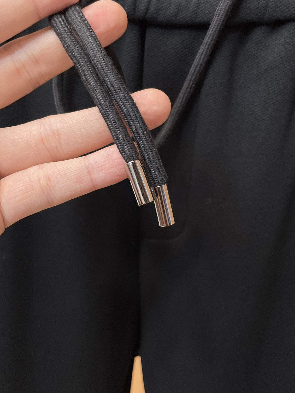Fendi pants drawstring with metal tips, shown on dark elastic waistband