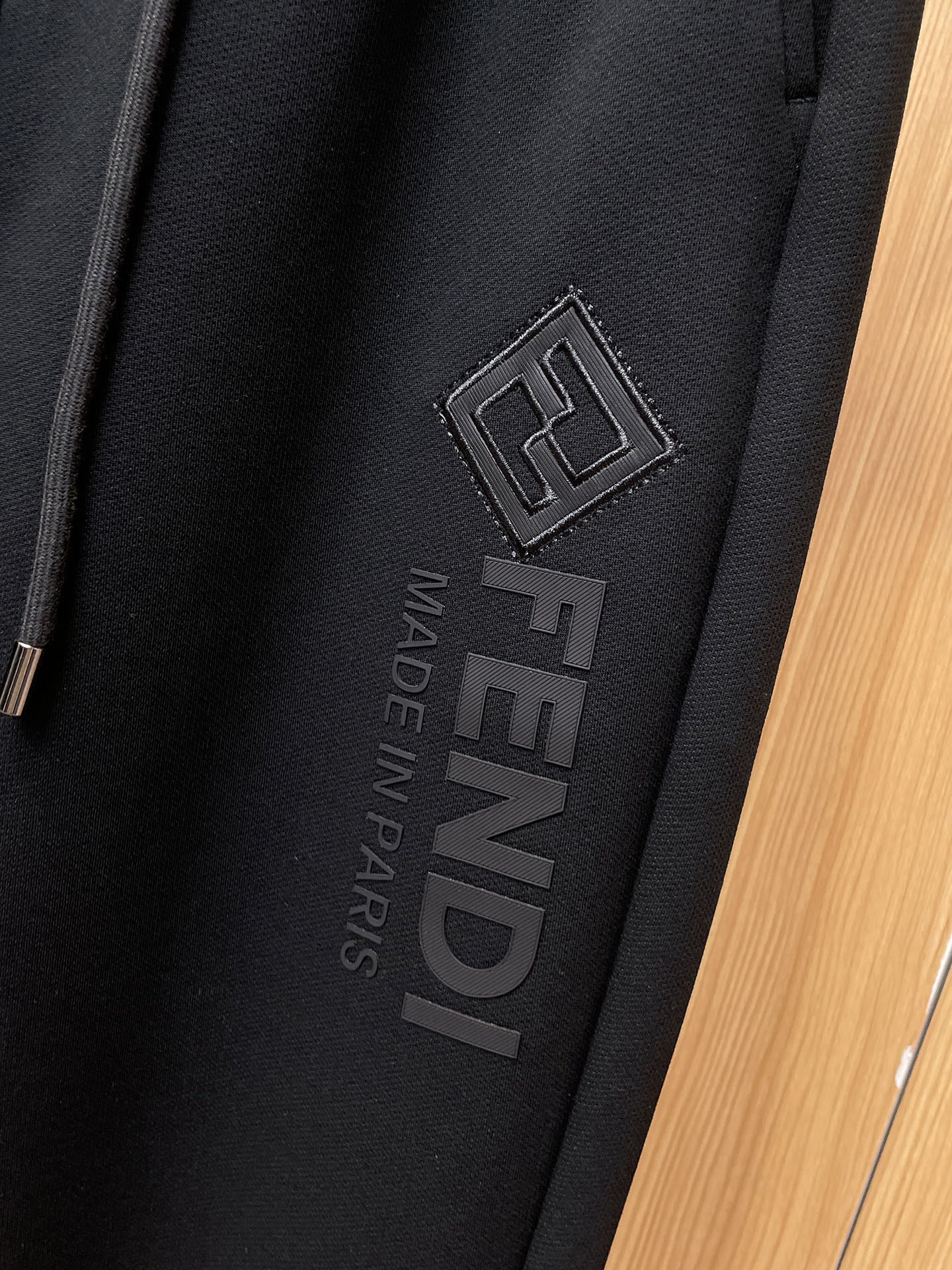Fendi pants vertical embossed logo with “MADE IN PARIS” on dark fabric