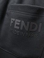 Fendi pants logo patch reading “FENDI” and “MADE IN PARIS” on dark fabric