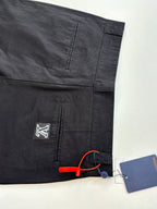 Dark pants with front and back pocket seams, logo patch, and hang tag
