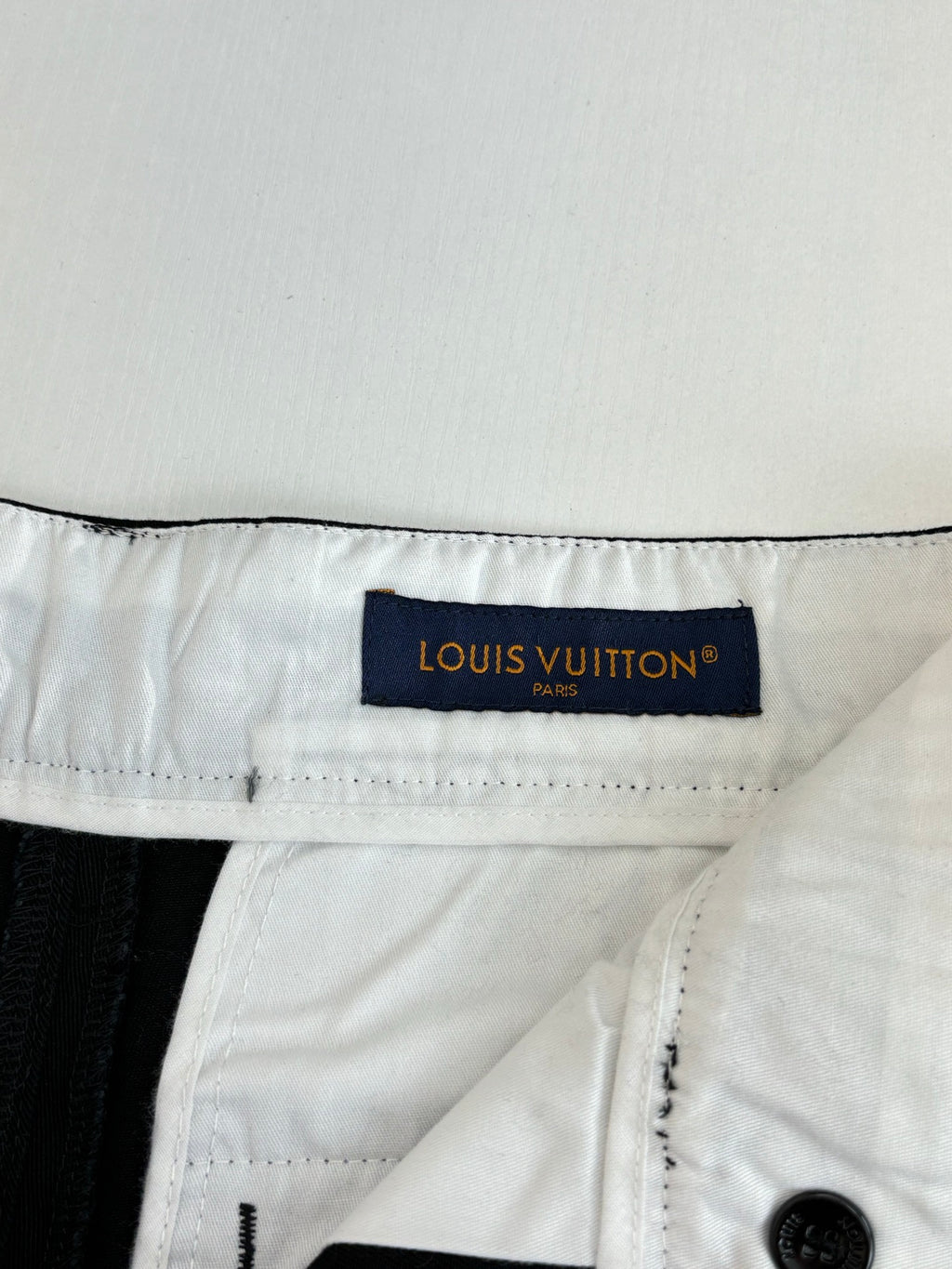 White fabric waistband label on dark pants with belt loops