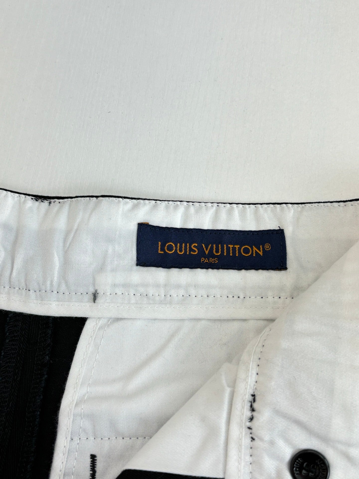 White fabric waistband label on dark pants with belt loops