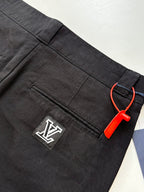 Dark pants with zip pocket and LV-style logo patch detail