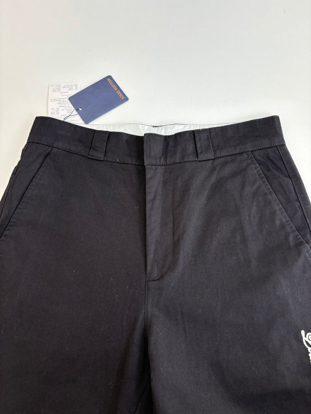 Dark pants with pleated waistband and back center seam detail