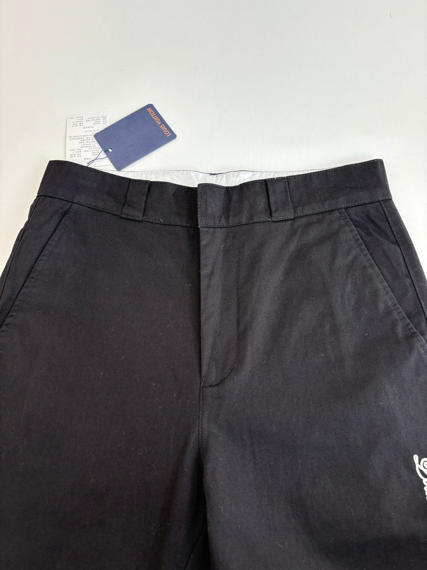 Dark pants with pleated waistband and back center seam detail