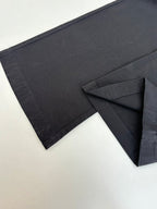 Dark pants with side cargo-style pocket opening and stitched panel detail