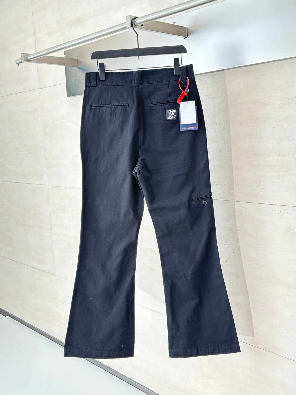 Navy straight-leg pants with front pockets, belt loops, and small side logo