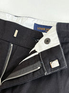 Dark pants waist with zip fly, button closure, and interior tag labels