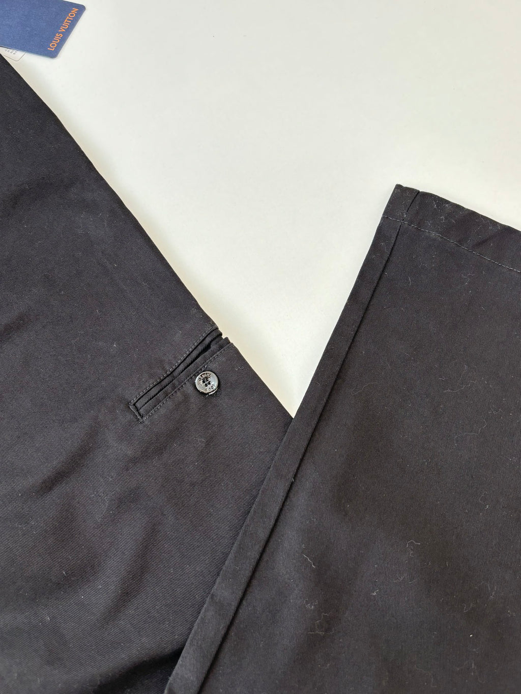 Dark tailored pants with button closure and belt loops at waistband
