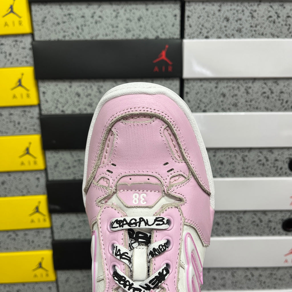 Pink low-top sneaker toe with lace-up eyelets and rubber cap detail.