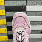 Pink low-top sneaker toe with lace-up eyelets and rubber cap detail.