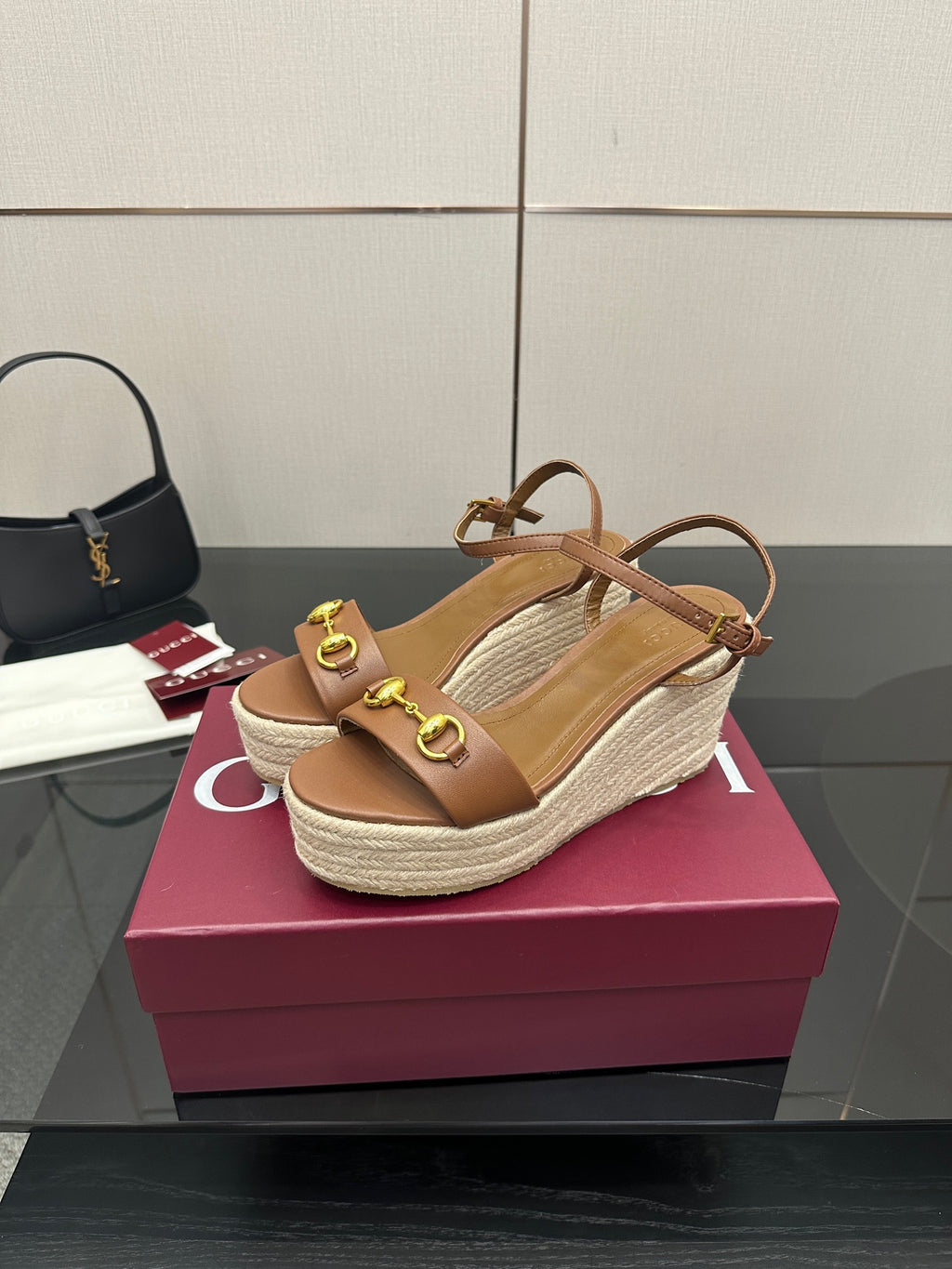 Tan leather wedge sandals with crisscross ankle straps and gold buckle detail