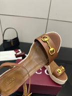 Tan leather sandal upper detail with gold buckle strap and espadrille platform