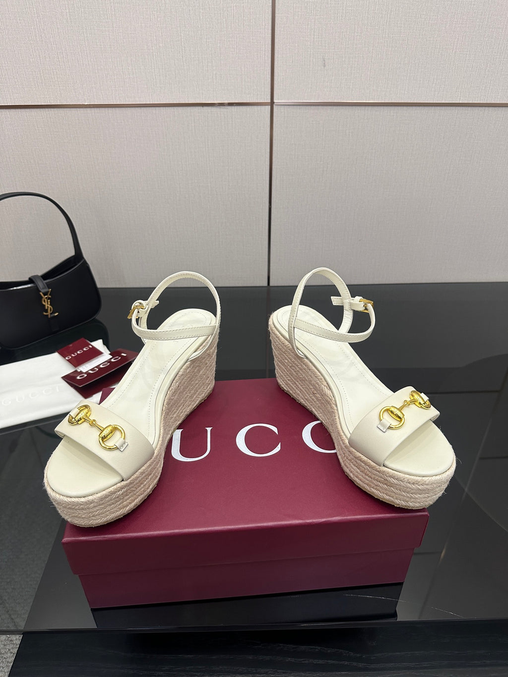 Gucci white wedge sandals with gold buckle detail and slingback ankle strap.
