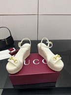 Gucci white wedge sandals with gold buckle detail and slingback ankle strap.