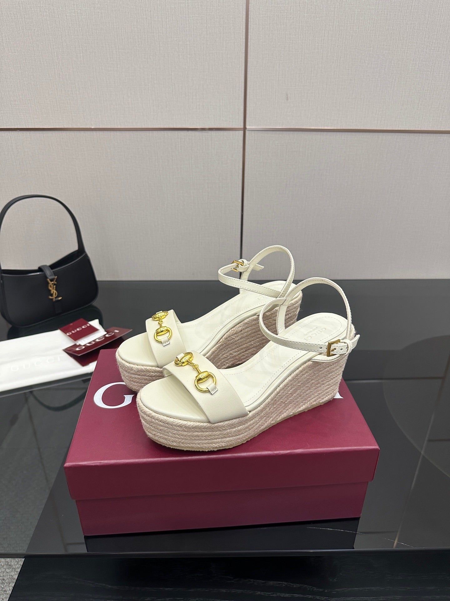 Gucci white platform wedge sandals with crisscross ankle straps and gold hardware.