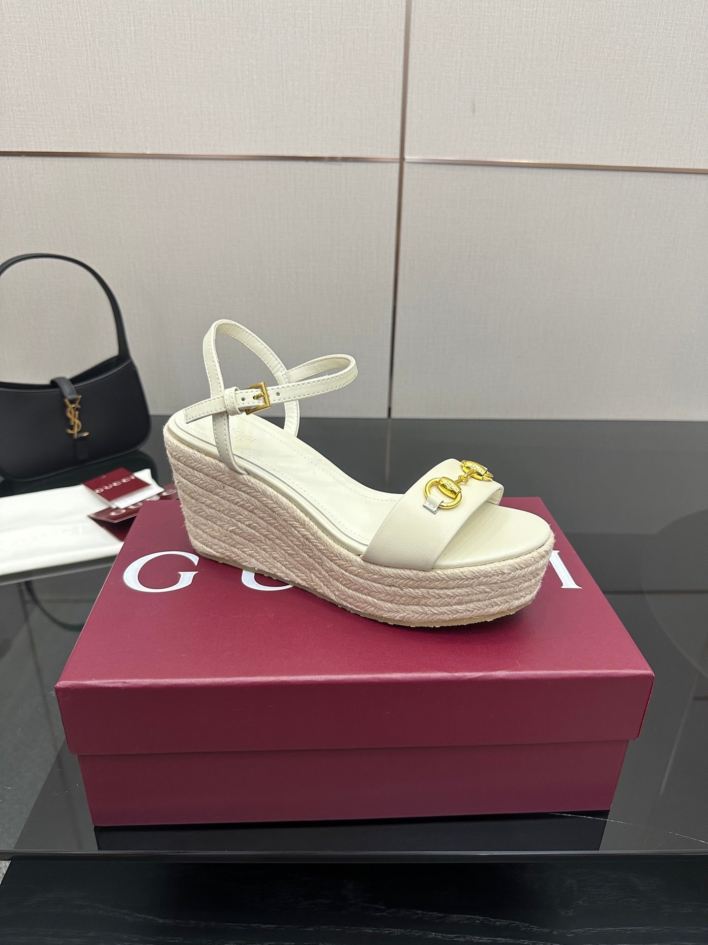 Gucci white platform wedge sandal with gold buckle ornament and ankle strap.