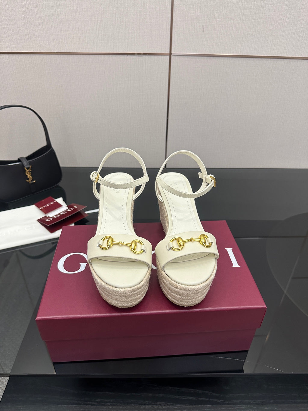 Gucci white platform wedge sandals with gold buckle detail and ankle straps.