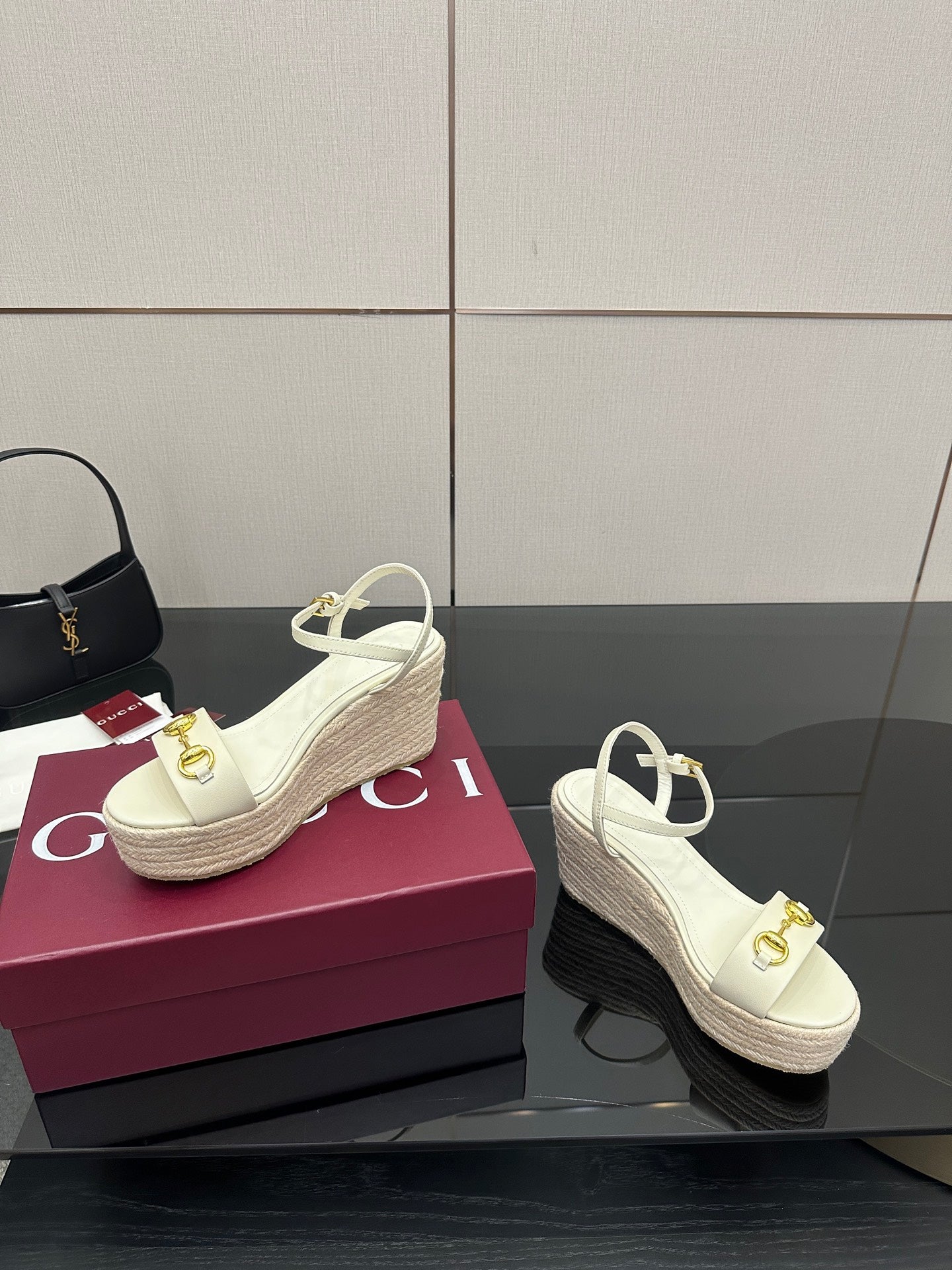Gucci white wedge sandals with gold buckle detail on platform espadrille sole.