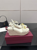 Gucci white wedge sandals with gold bit buckle and lace-up ankle straps.