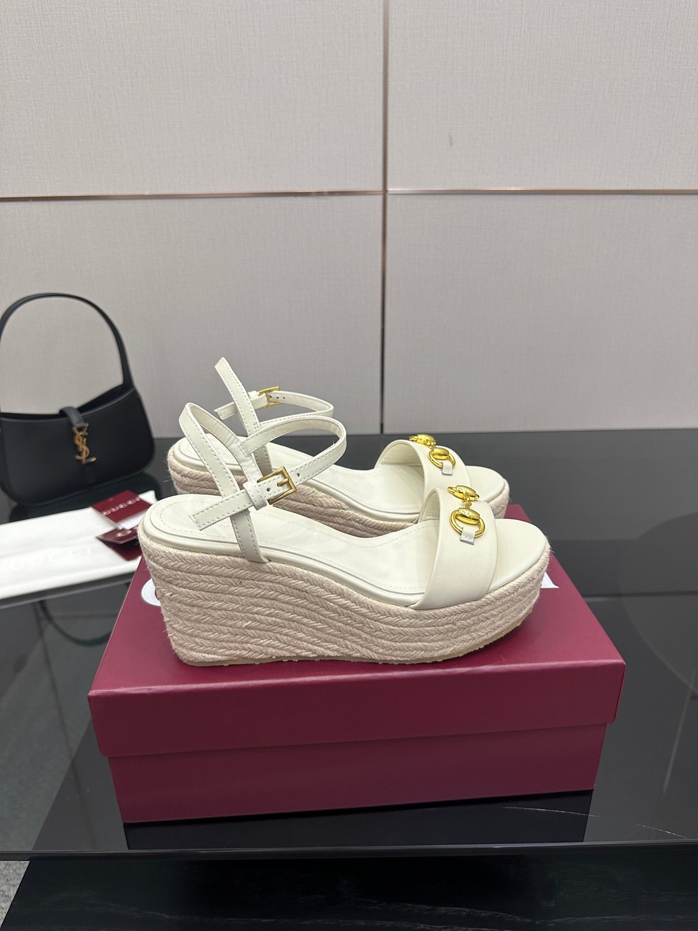 Gucci white wedge sandals with gold bit buckle and lace-up ankle straps.