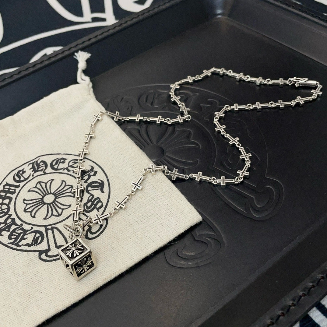 Silver-tone cross-link chain necklace with square pendant on box and pouch