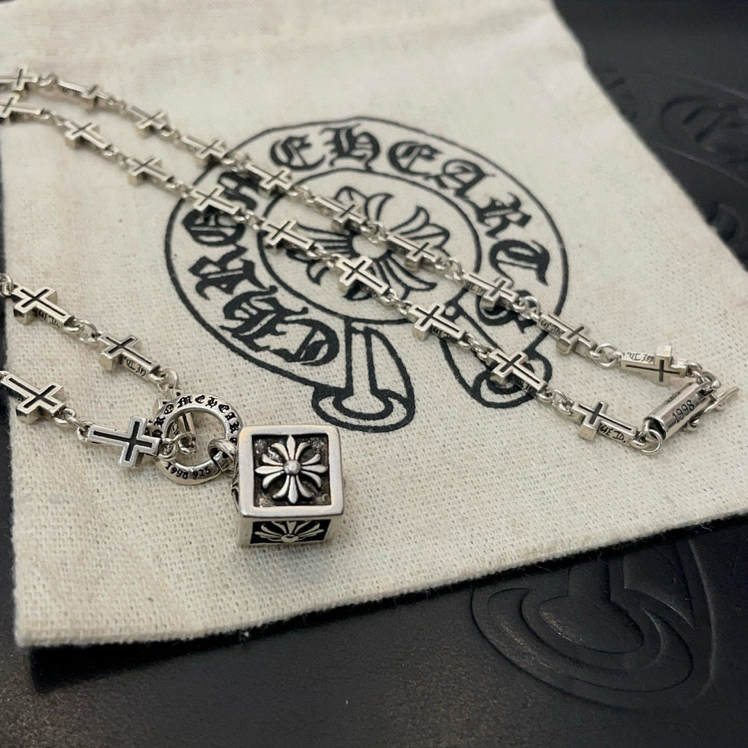 Silver-tone cross-link chain necklace with square pendant and starburst charm detail