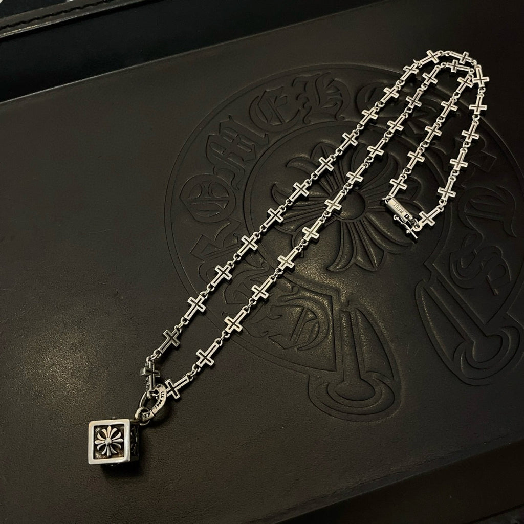 Silver-tone cross-link chain necklace with square pendant charm on dark box