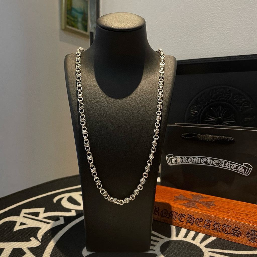 Metal chain necklace on black display bust
