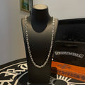 Metal chain necklace on black display bust