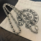 Layered metal chain necklaces on beige pouch
