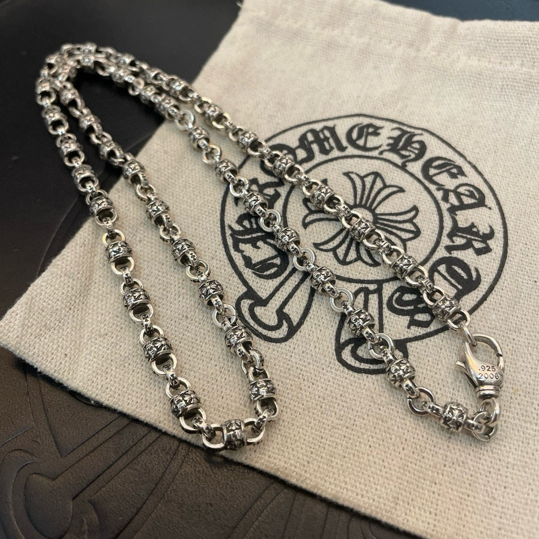 Layered metal chain necklaces on beige pouch