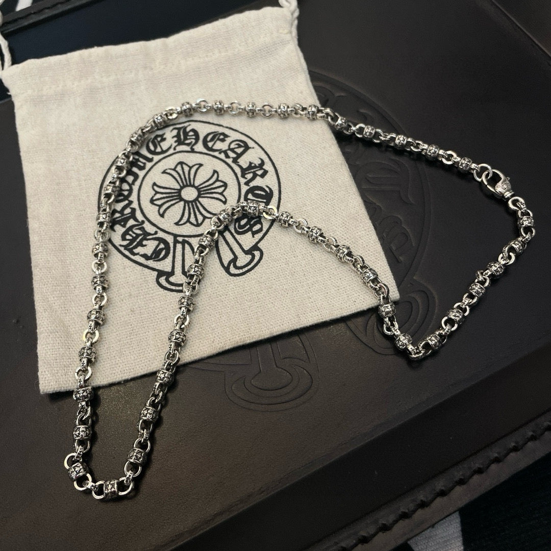 Metal chain necklaces on beige pouch over black jewelry box