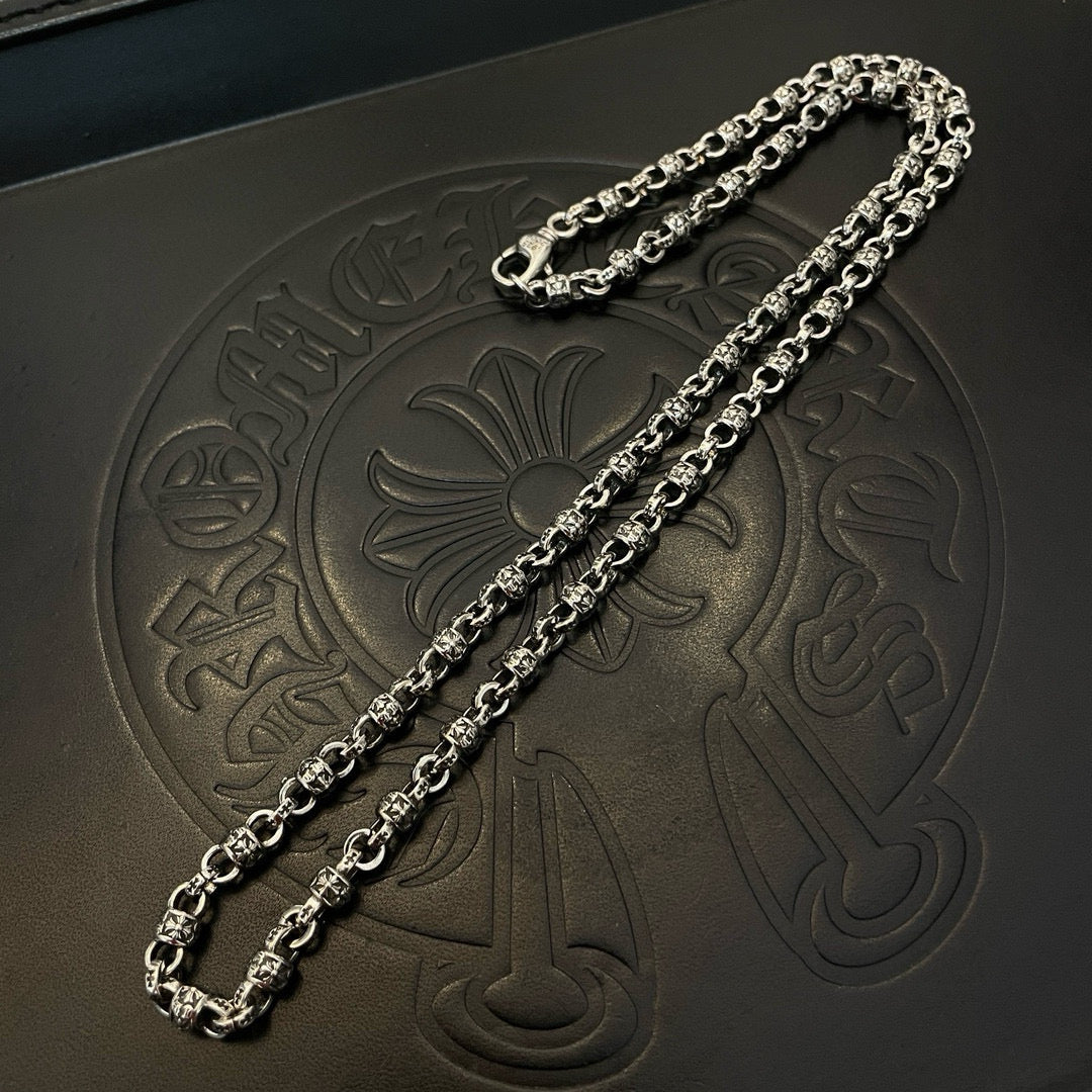 Two metal chain necklaces on black jewelry box surface