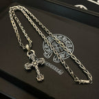 Cross pendant necklace laid on a box, silver-toned chain and cross charm