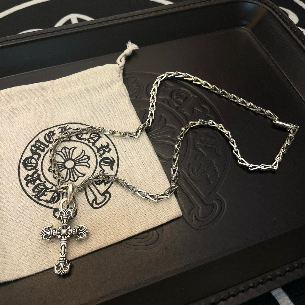 Cross pendant necklace with silver-toned chain and cross charm on a pouch