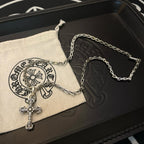 Cross pendant necklace with silver-toned chain and cross charm on a pouch