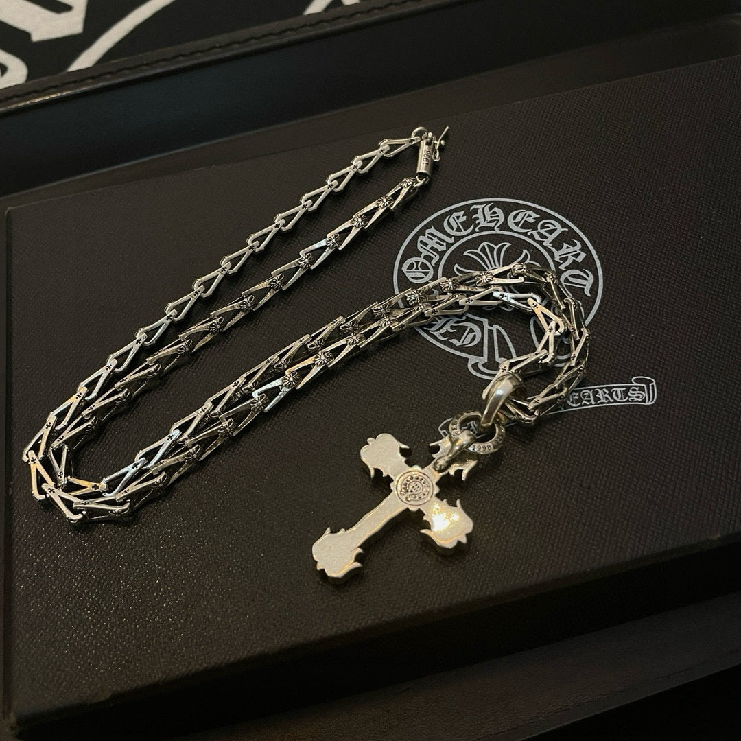 Cross pendant necklace with silver-toned chain and cross charm on a black box