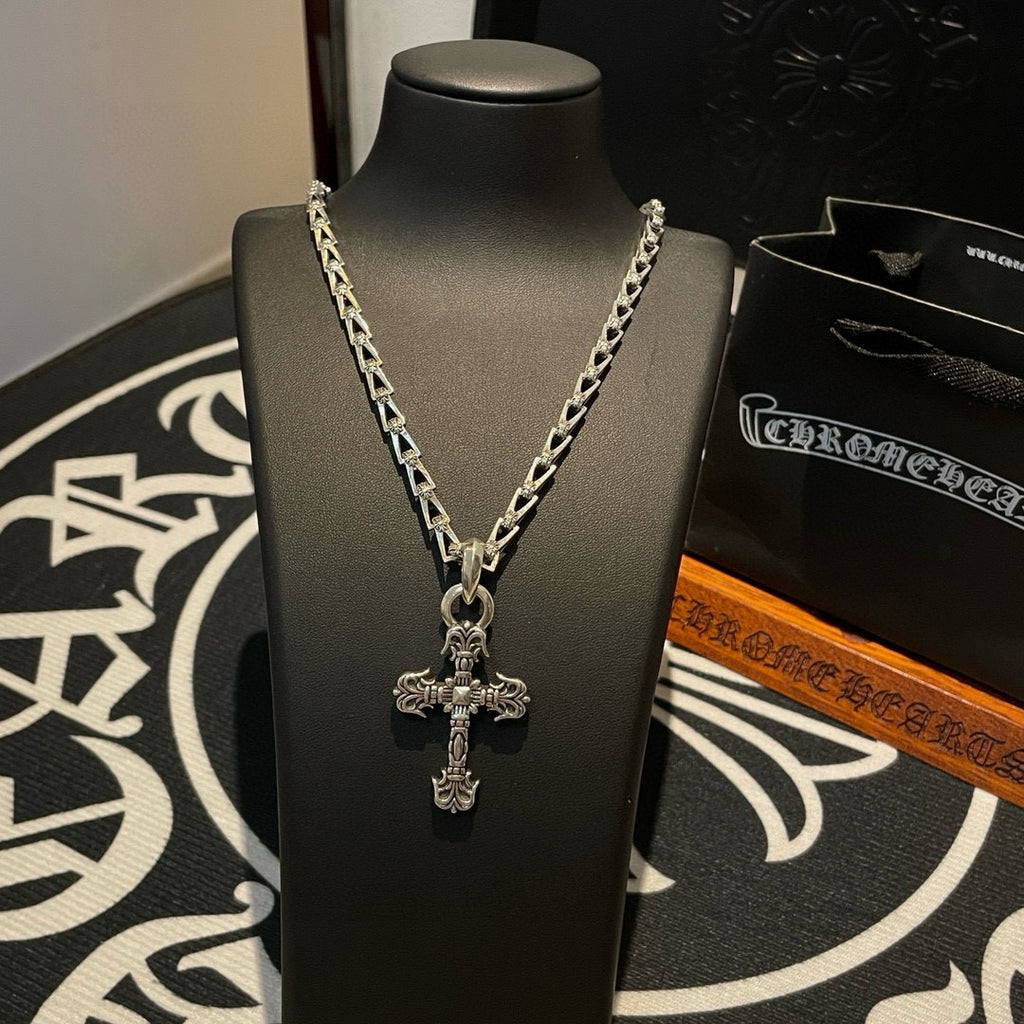Cross pendant necklace on bust, silver-toned chain with ornate cross pendant