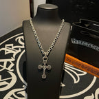 Cross pendant necklace on bust, silver-toned chain with ornate cross pendant