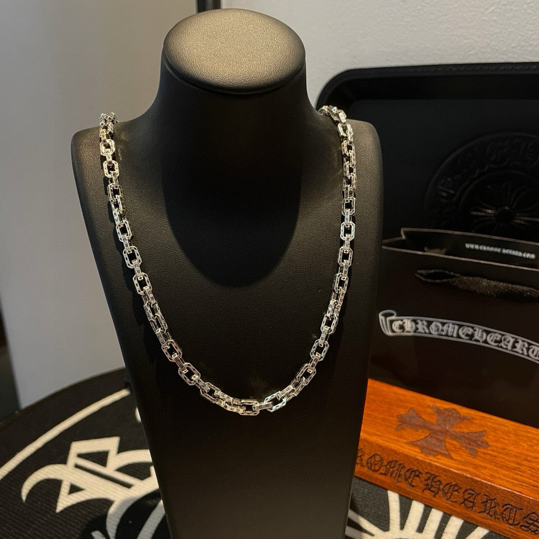 Silver-tone chain necklace with thick links on black display bust.