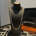 Silver-tone chain necklace on black display bust.