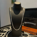 Silver-tone chain necklace on black display bust.