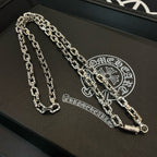 Silver-tone chain necklace with thick links on black tray, layered strands.