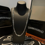 Silver-tone chain necklace with thick links on black display stand.