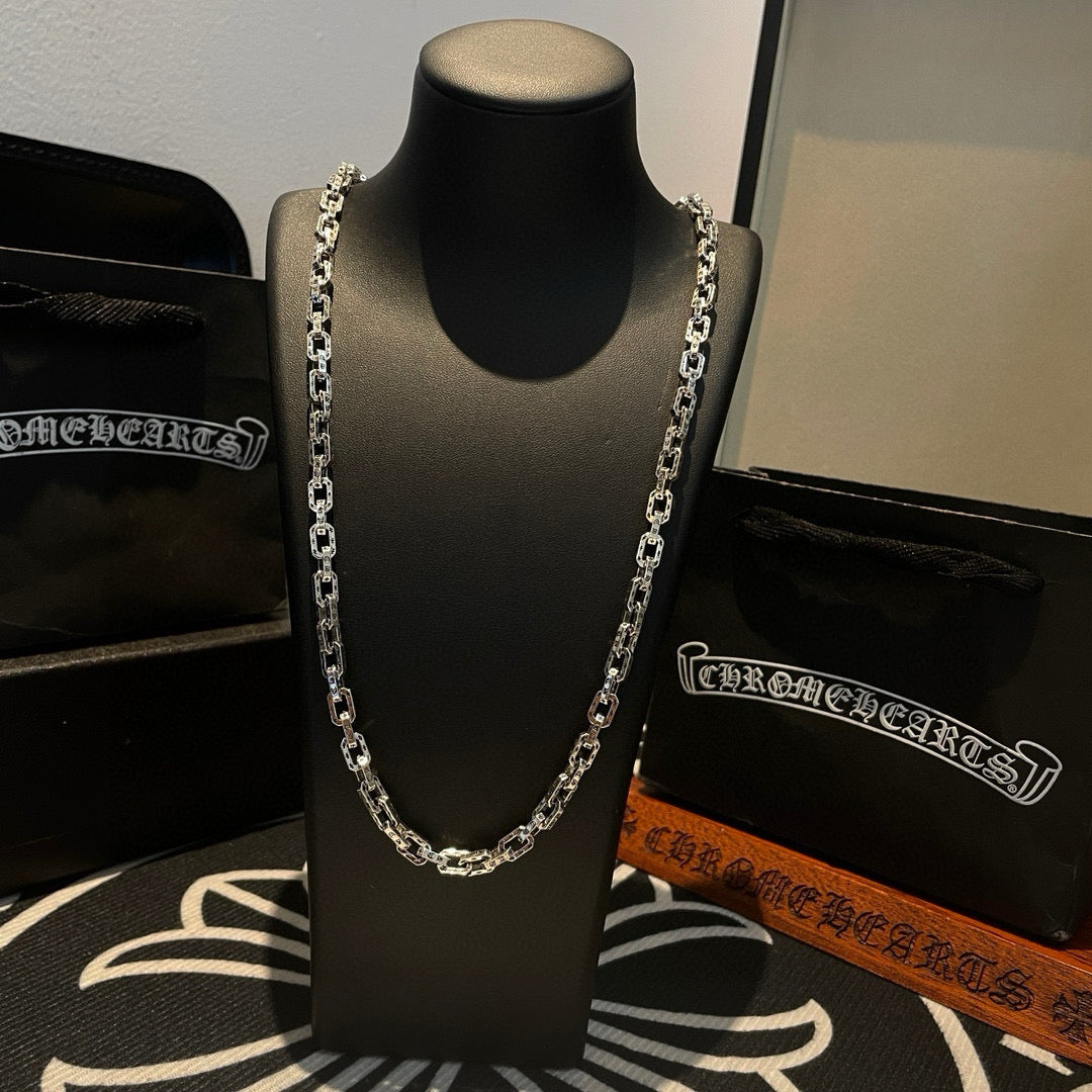 Silver-tone chain necklace with thick links on black display stand.