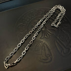 Silver-tone chain necklace with thick links on black leather tray.