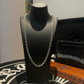 Silver-tone chain necklace on black display bust with layered links